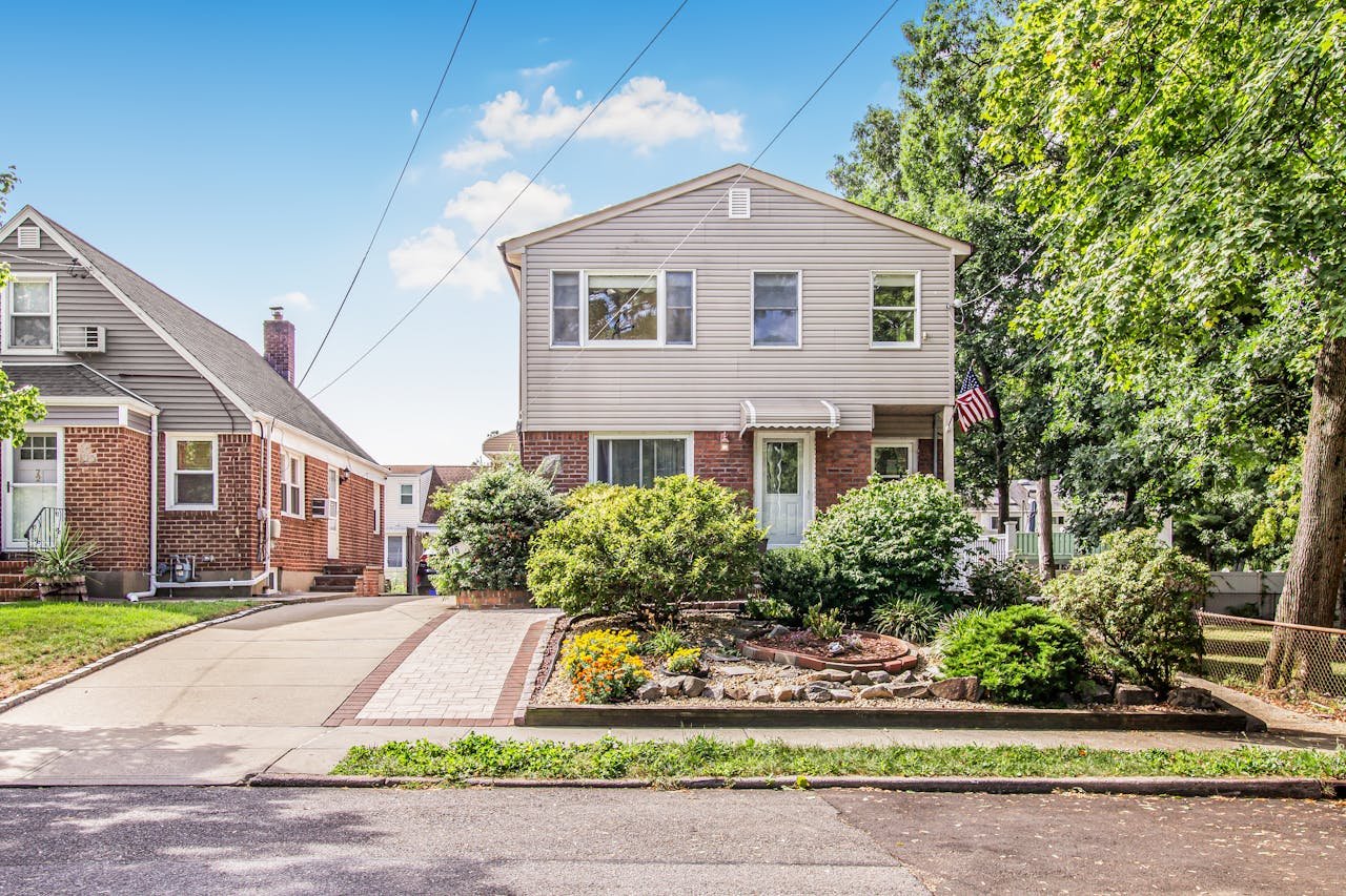 Residential property in Rochester Hills with landscaped front yard, driveway, and neighboring homes, showcasing potential for multifamily management and tenant representation services.