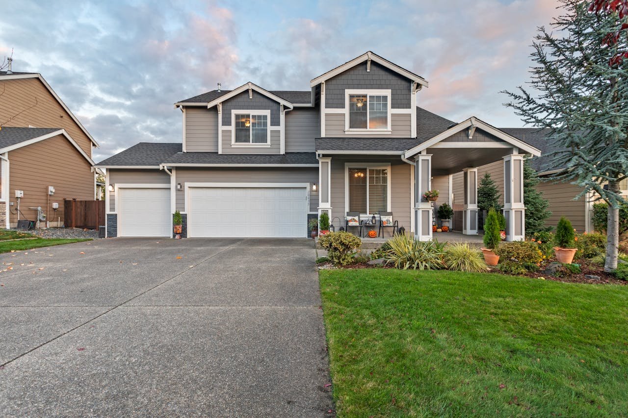 Modern two-story residential home with a landscaped front yard, featuring a two-car garage, porch, and decorative elements, representing ValCrest Properties' focus on multifamily real estate solutions in Rochester Hills.