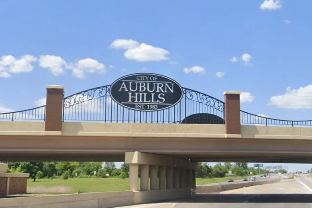 Modern arched gateway structure spanning a road in Auburn Hills, Michigan
