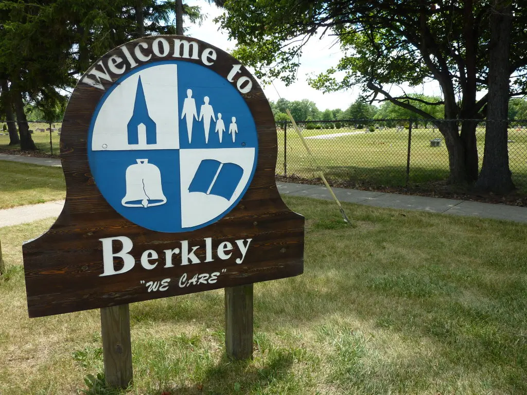 Blue circular Berkley city sign on a lawn in Berkley, Michigan
