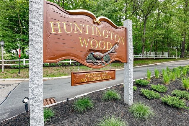 Stone and wood Huntington Woods entrance sign with landscaping in Huntington Woods, Michigan
